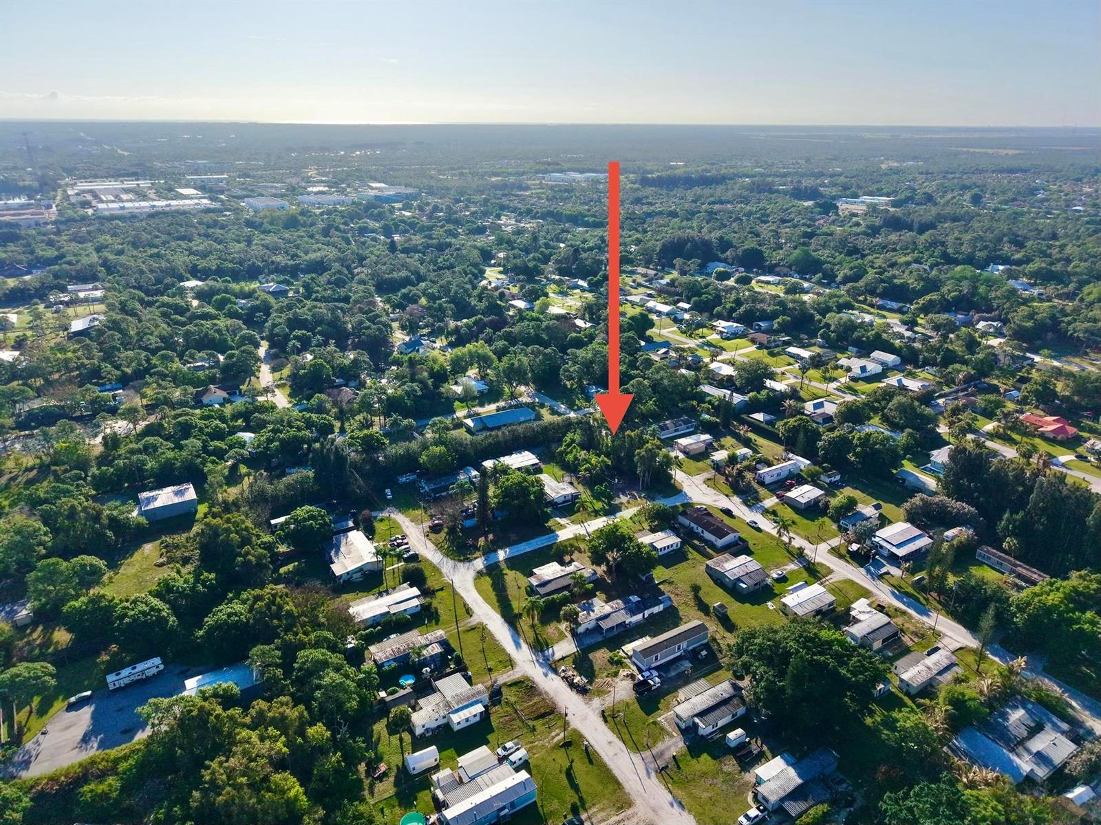 An aerial view shows a residential neighborhood with a red arrow pointing toward a lot — 0 Unassigned, Stuart FL 34997, STUART, FL