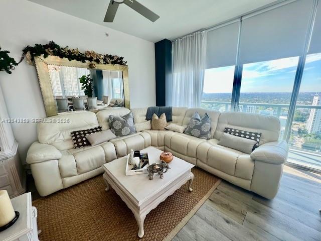 A living room features a large white sectional sofa, a coffee table, and a mirror — 1111 SW 1st Ave # 3225, Miami FL 33130, MIAMI, FL