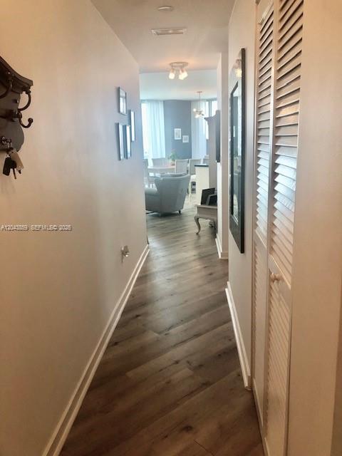 A hallway with wood-look flooring leads to a living area with a light blue chair — 1111 SW 1st Ave # 3225, Miami FL 33130, MIAMI, FL