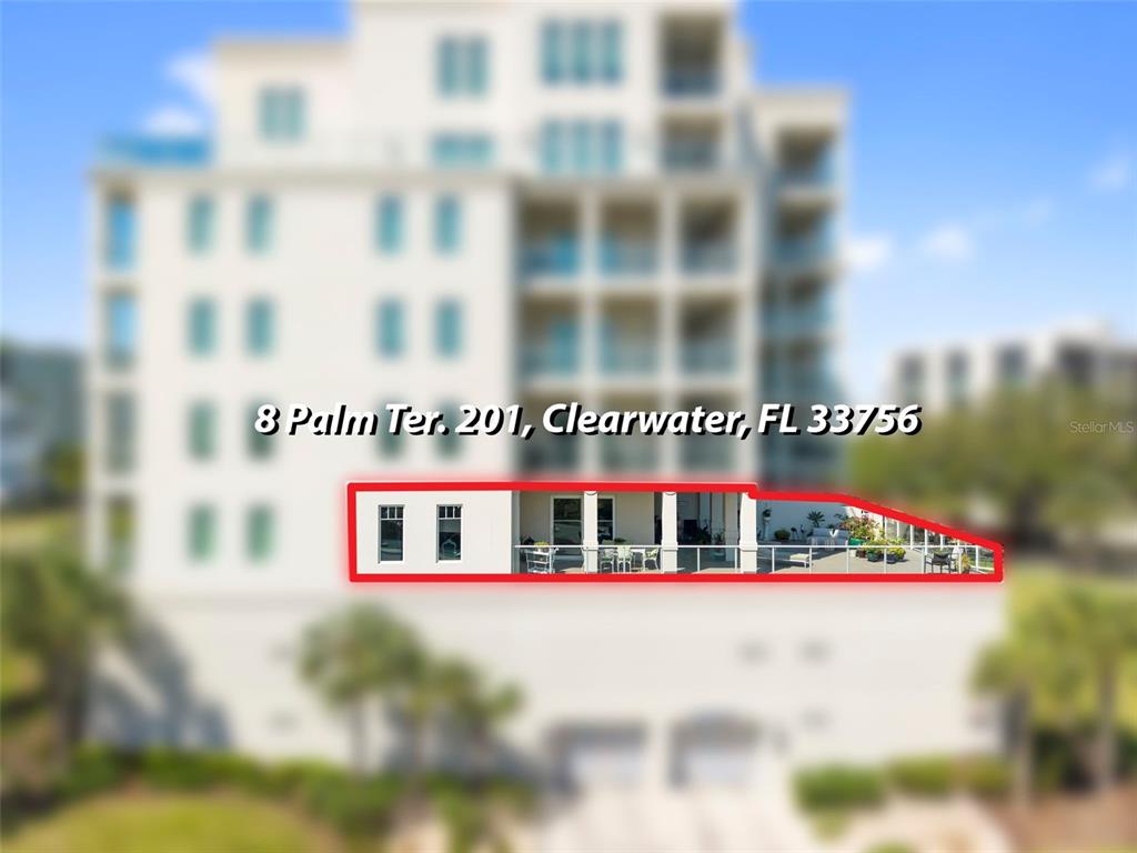 An exterior view of a multi-story building highlighting a second-floor balcony with outdoor furniture — 8 PALM TERRACE UNIT 201, CLEARWATER, FL