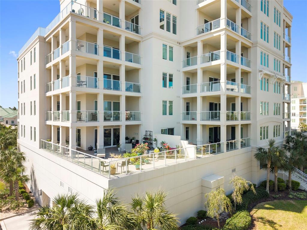 An exterior view of a multi-story apartment building with balconies and a ground-level terrace — 8 PALM TERRACE UNIT 201, CLEARWATER, FL