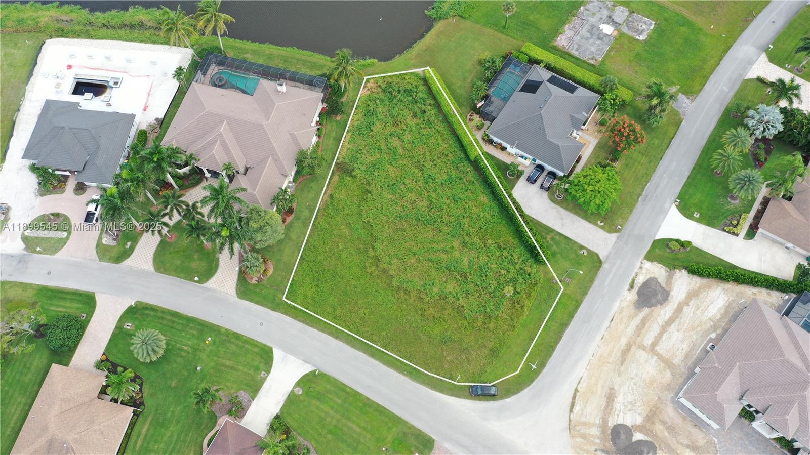 An aerial view shows a vacant, irregularly shaped residential lot situated between two houses — 18018 Royal Hammock Blvd, Naples FL 34114, NAPLES, FL