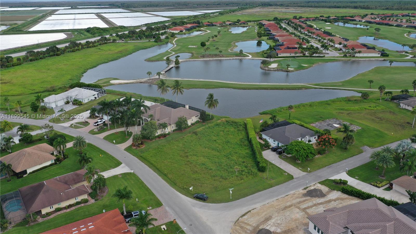 An aerial view shows a vacant residential lot situated next to a lake and golf course — 18018 Royal Hammock Blvd, Naples FL 34114, NAPLES, FL