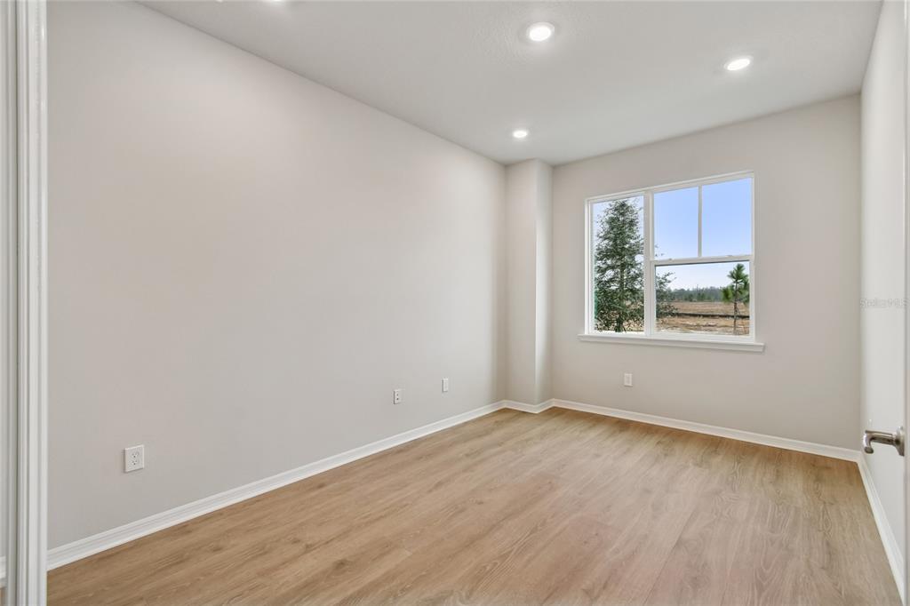 An entryway features light wood flooring, a staircase with white railings, and a glass-paneled door — 9334 HARTLINE WAY, ORLANDO, FL