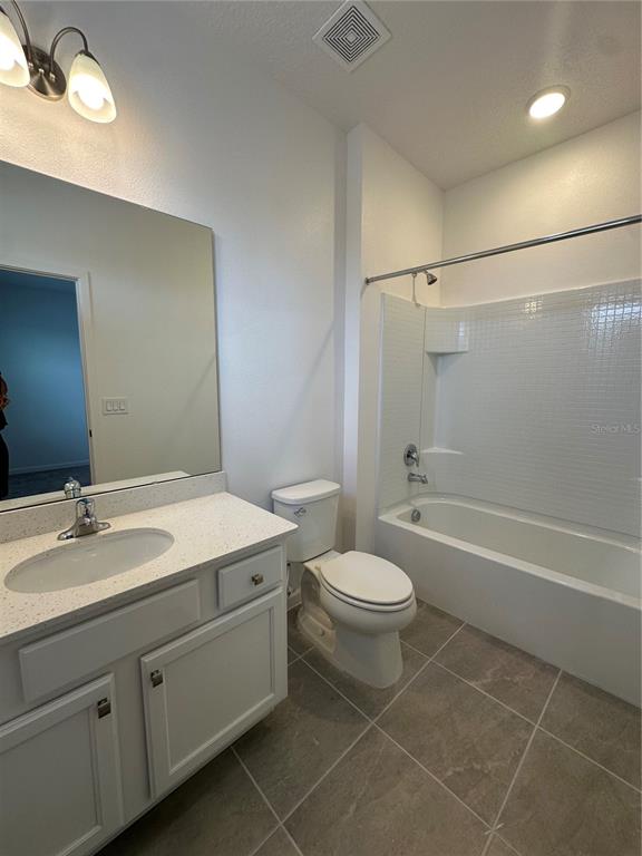 A bathroom features a white vanity with a sink, a toilet, and a tiled shower-tub — 3800 SONOMA BOULEVARD, KISSIMMEE, FL