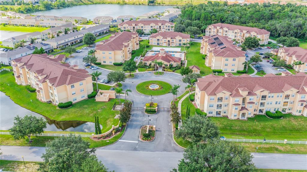 An aerial view shows a gated apartment complex with multiple buildings, a central roundabout, and landscaping — 505 TERRACE RIDGE CIRCLE UNIT 505, DAVENPORT, FL