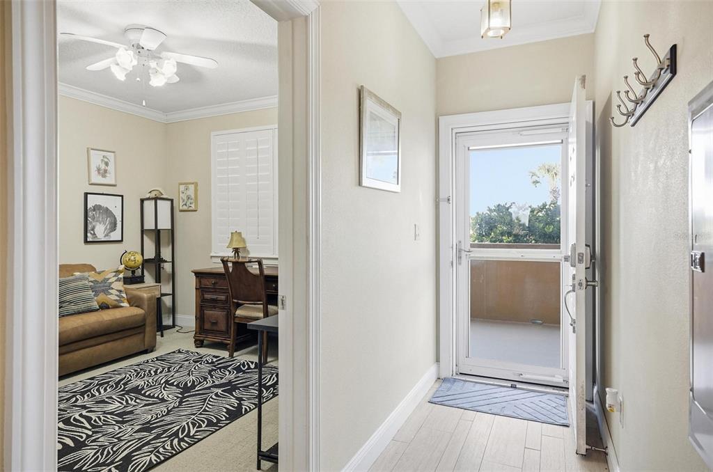 A view from a tiled entryway looking into a furnished home office with a rug — 60 SURFVIEW DRIVE UNIT 122, PALM COAST, FL