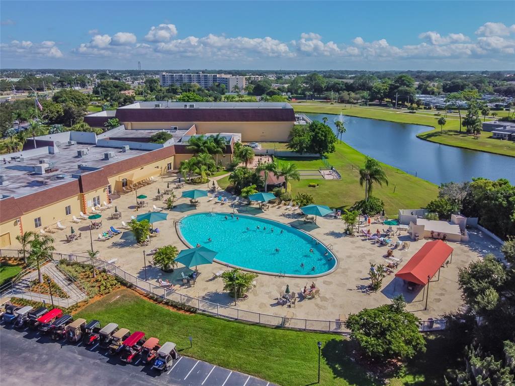 An aerial view shows a swimming pool, patio area, and golf cart parking lot — 1105 JAMESON GREENS DRIVE UNIT 1105, SUN CITY CENTER, FL