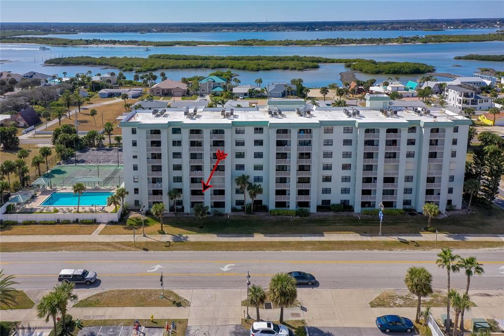 An aerial view shows a multi-story apartment building with a swimming pool and tennis court — 3800 S ATLANTIC AVENUE UNIT 207, DAYTONA BEACH, FL