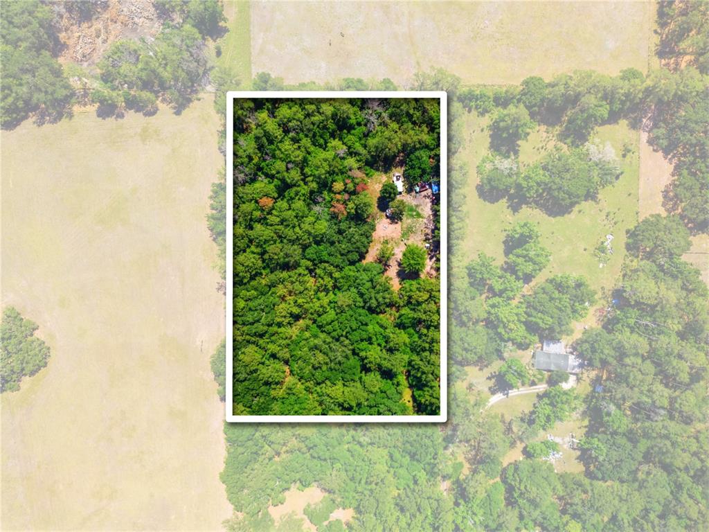 An aerial view shows a rectangular wooded lot surrounded by open fields and trees — 1074 CULBREATH ROAD, BROOKSVILLE, FL