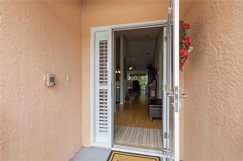 An open front door reveals a view into a home with hardwood flooring — 19310 WATER OAK DRIVE UNIT 203, PORT CHARLOTTE, FL