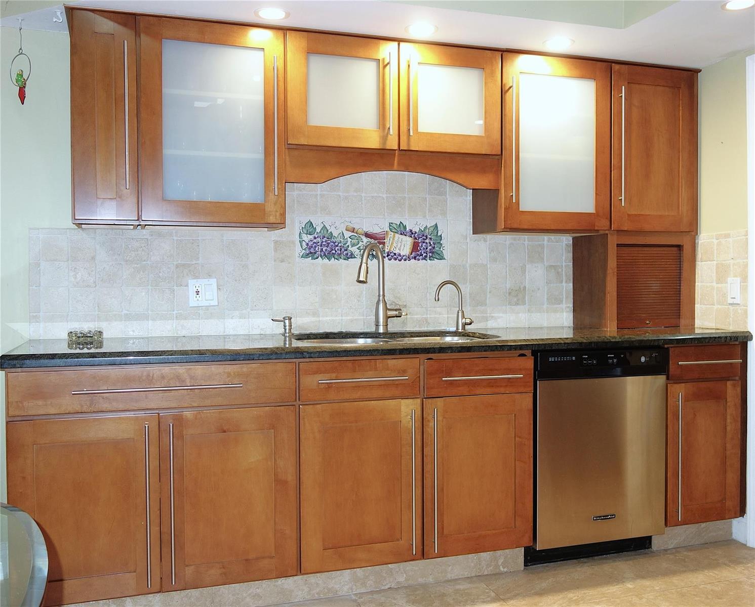 A kitchen features wood cabinets, stainless steel appliances, a tile backsplash, and dark granite countertops — 4106 Carriage Drive # 5C, Pompano Beach FL 33069, POMPANO BEACH, FL