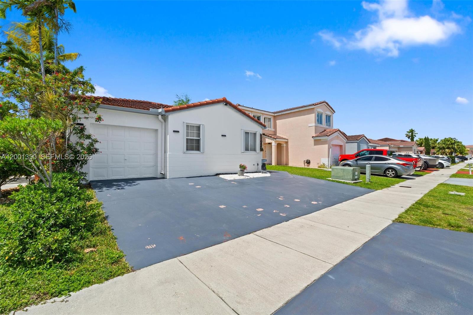 A white single-story house with a garage and driveway sits under a blue sky — 17434 SW 143rd Pl, Miami FL 33177, MIAMI, FL