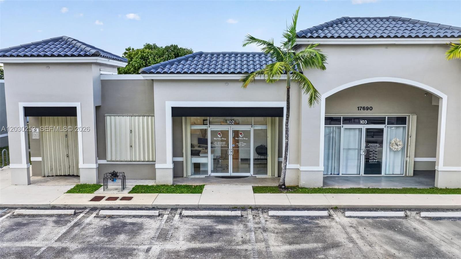 An exterior view of a commercial building with two storefronts and a palm tree — 17690 NW 78th Ave, Hialeah FL 33015, HIALEAH, FL