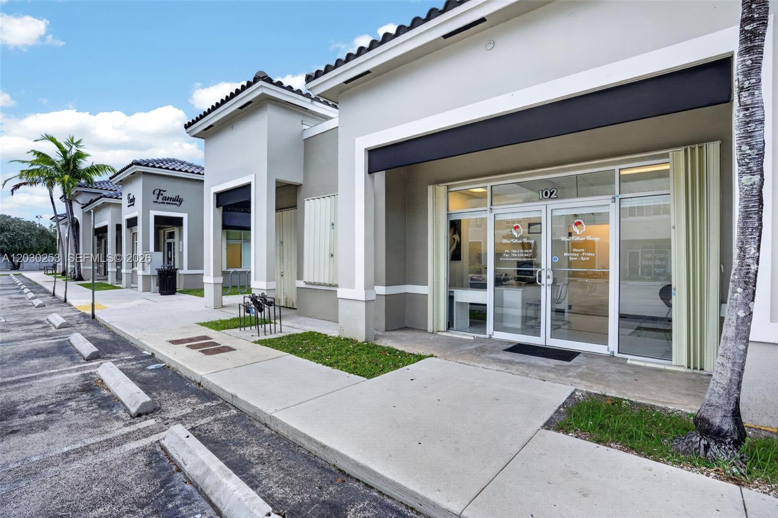 An exterior view of a commercial building with glass storefronts and a parking lot — 17690 NW 78th Ave, Hialeah FL 33015, HIALEAH, FL