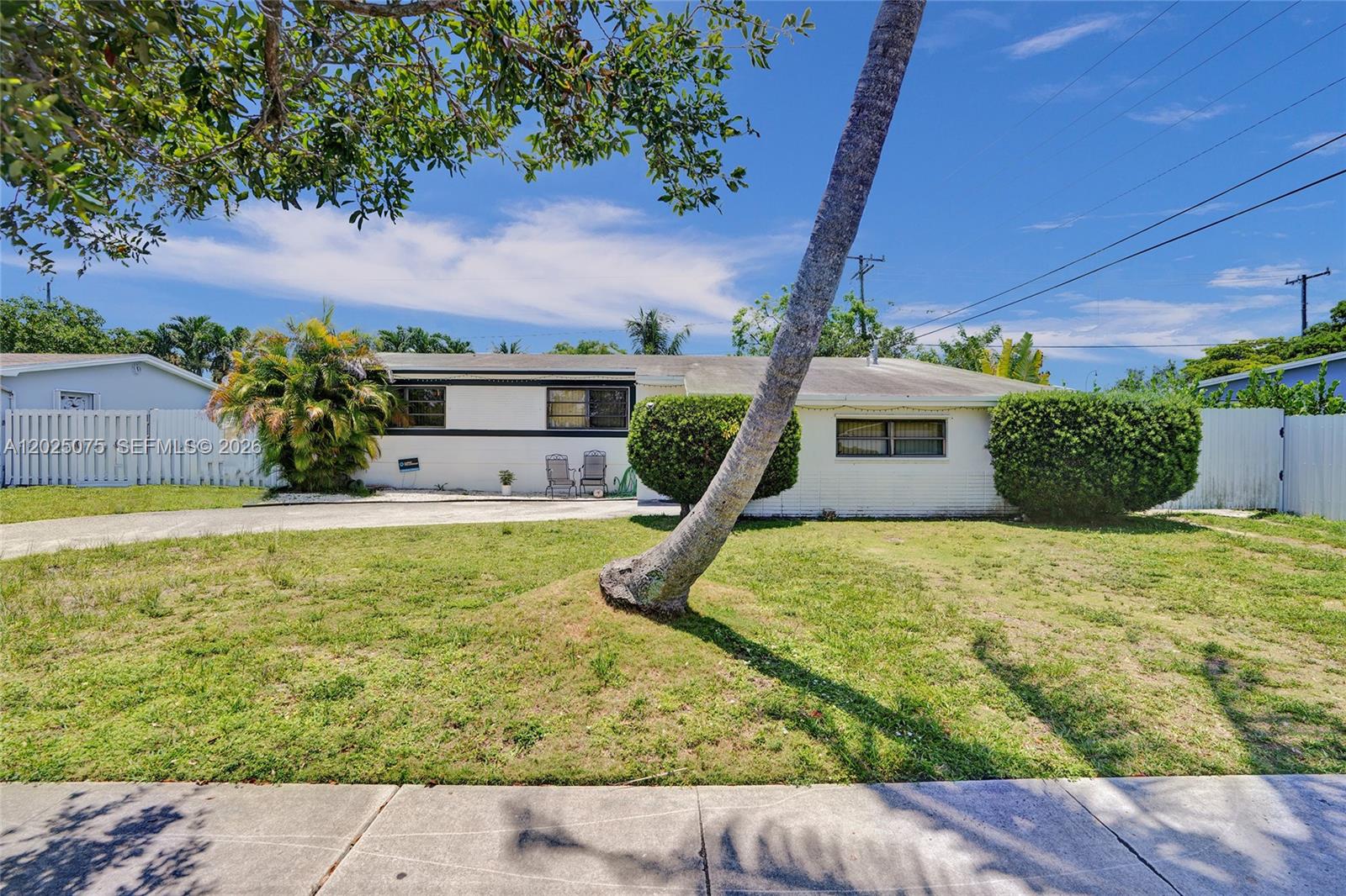 A single-story white house with a slanted palm tree in the front yard — 9910 Bahama Dr, Cutler Bay FL 33189, CUTLER BAY, FL