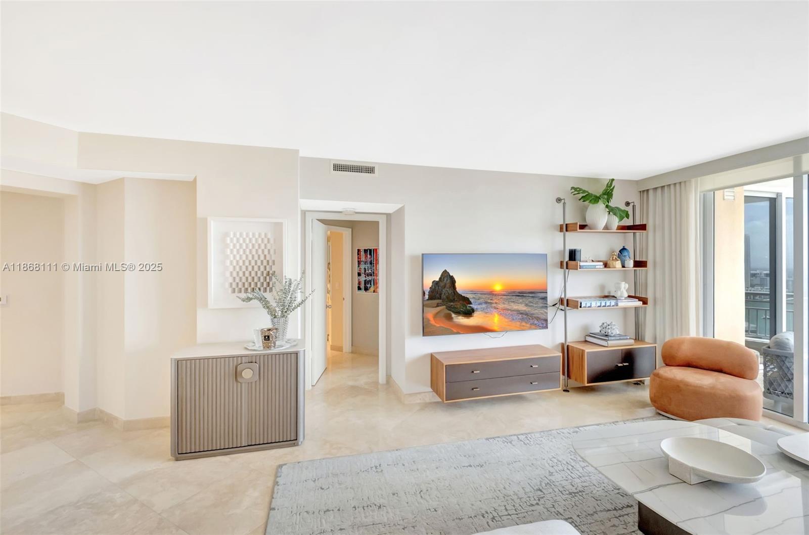 A modern living room features a wall-mounted television, floating media console, and open shelving — 848 Brickell Key Dr # 2605, Miami FL 33131, MIAMI, FL