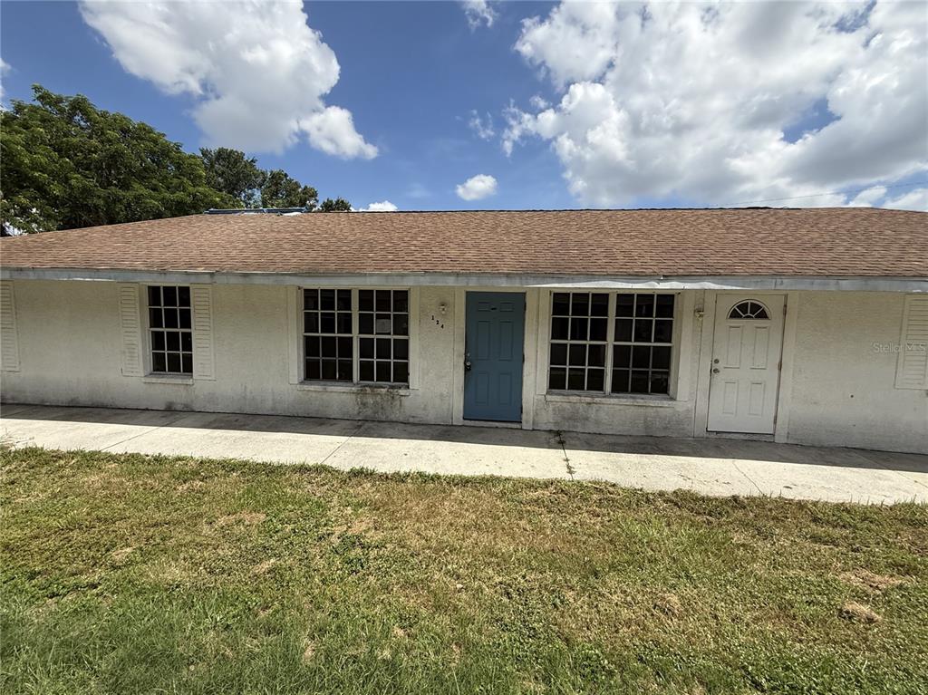 A single-story house exterior features a white stucco facade, a brown roof, and two doors — 3124 11TH STREET COURT E, BRADENTON, FL