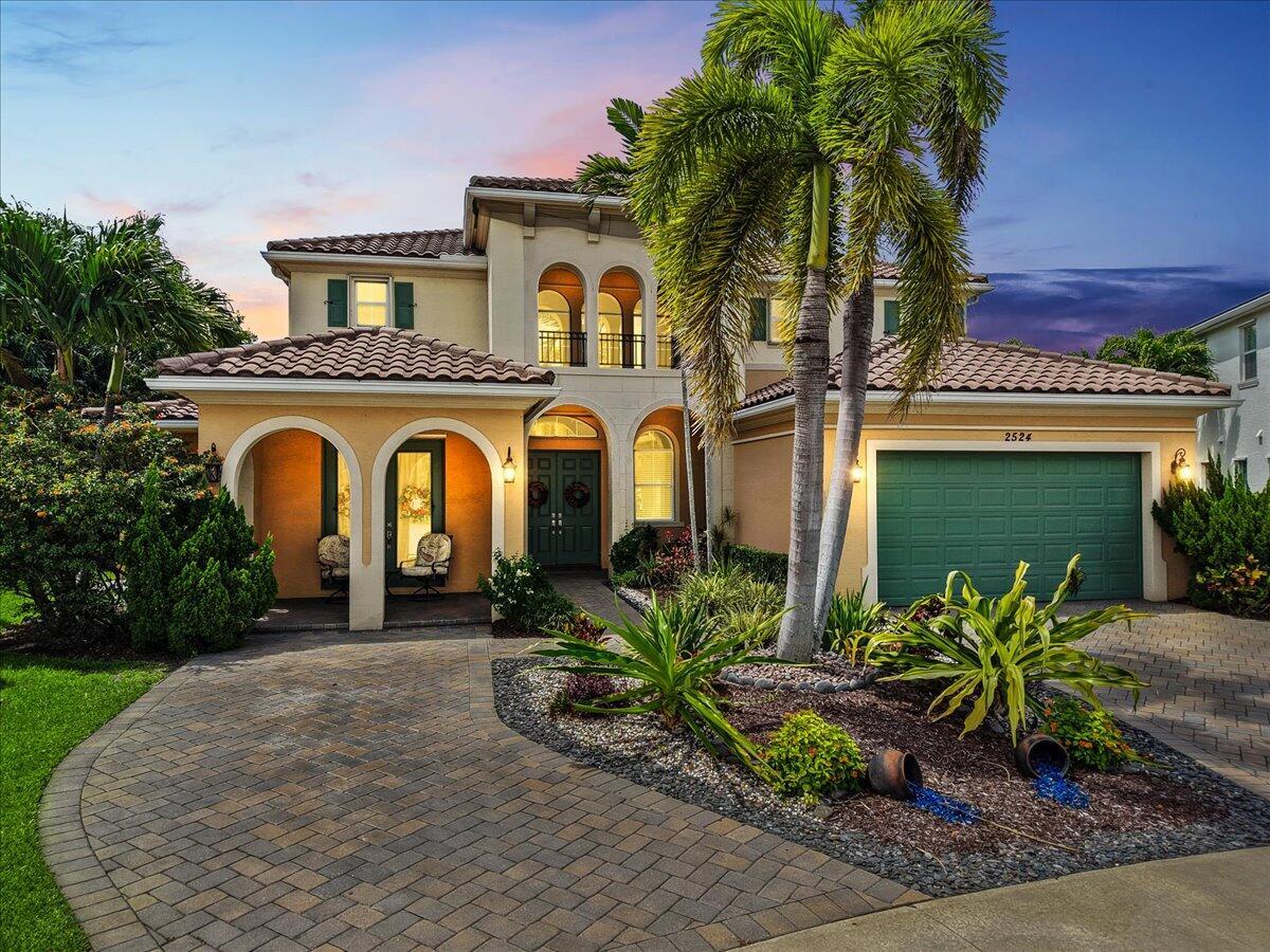 A two-story stucco house with a green garage door and palm trees in the front — 2524 Cooper Way, Wellington FL 33414, WELLINGTON, FL