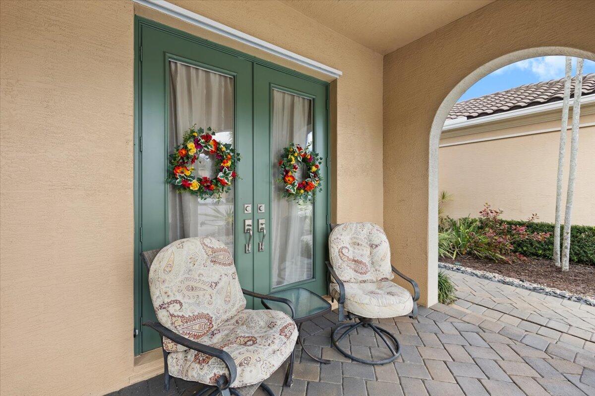 A paved walkway leads to a green double front door under a covered arched entryway — 2524 Cooper Way, Wellington FL 33414, WELLINGTON, FL