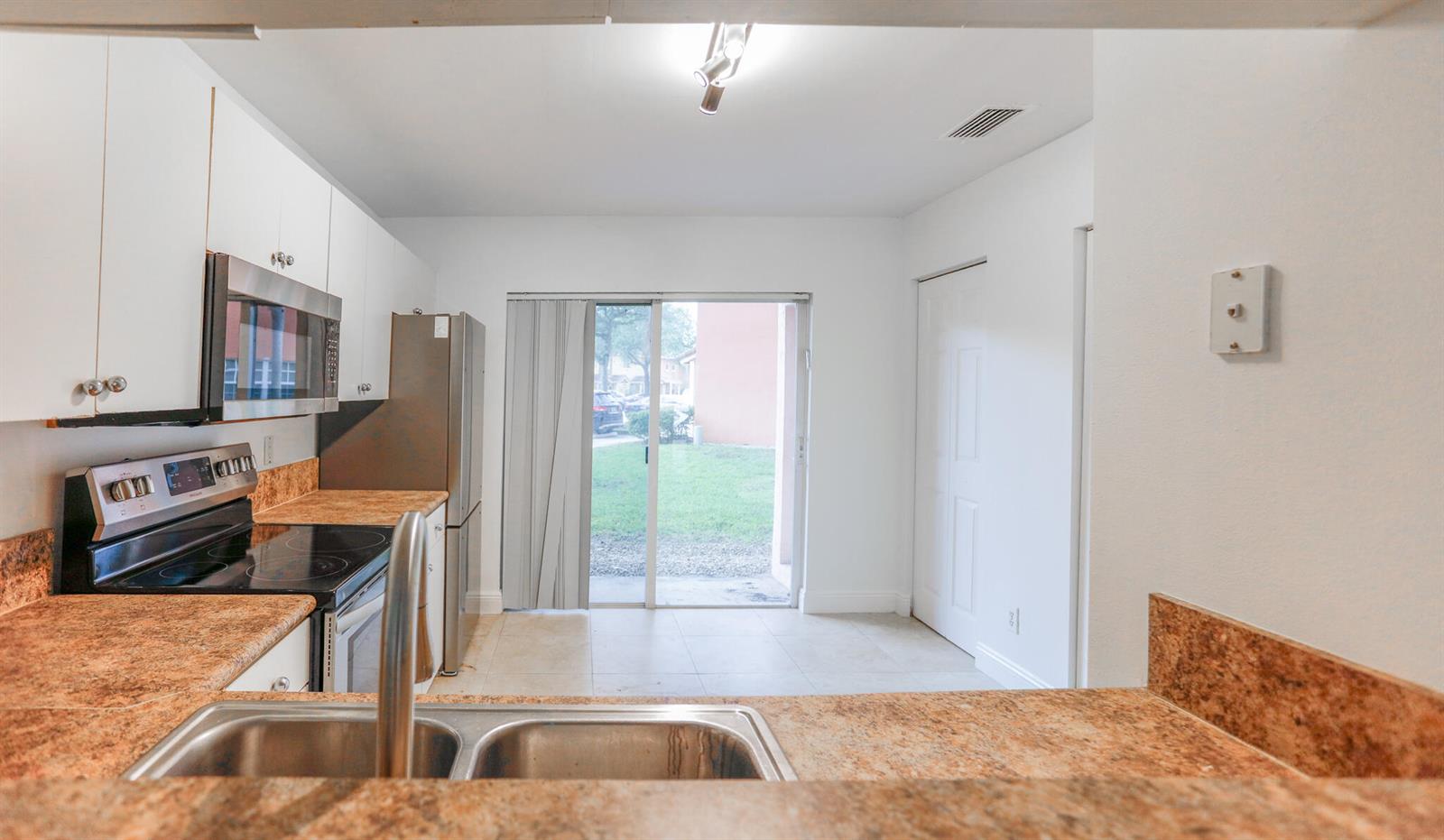 A kitchen with granite countertops, stainless steel appliances, and a sliding glass door to outside — 4149 NW 67th Te # 4149, Lauderhill FL 33319, LAUDERHILL, FL