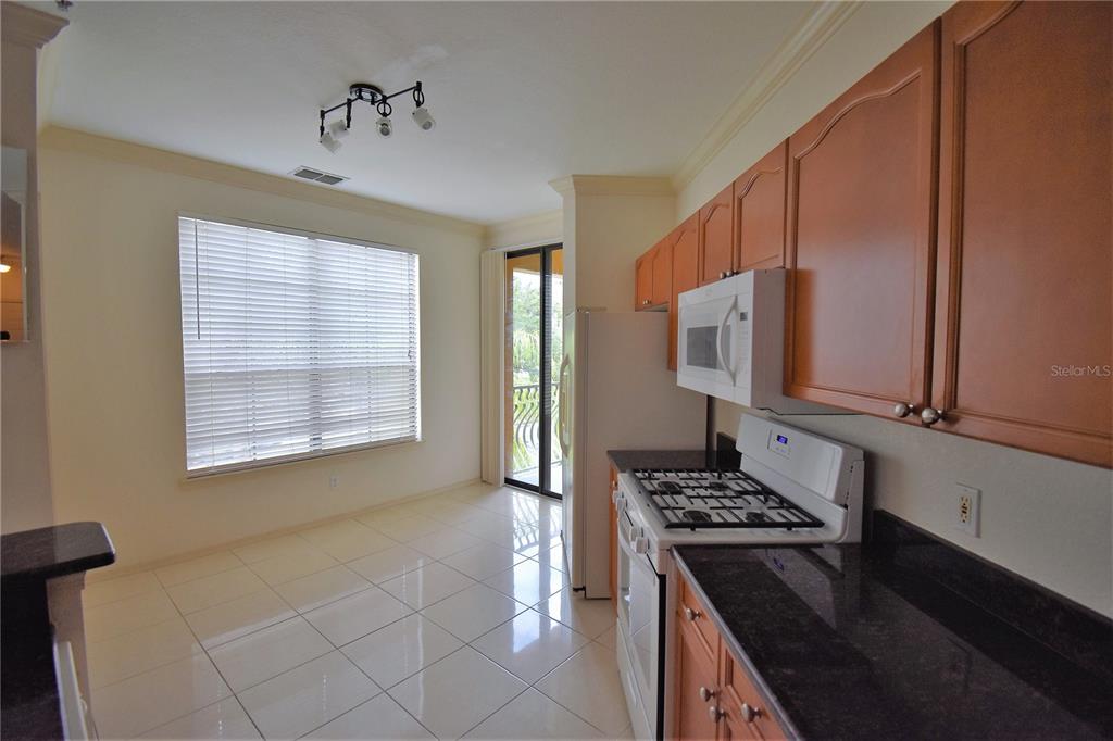 A room with hardwood floors, a ceiling fan, and a glass-paned French door — 2722 VIA TIVOLI UNIT 420A, CLEARWATER, FL