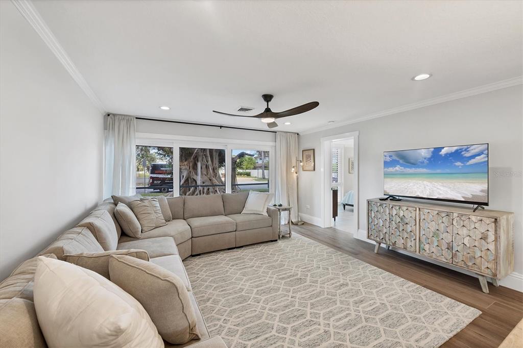 A living room features a large sectional sofa, a patterned area rug, and a media console — 500 S WASHINGTON DRIVE UNIT 11A, SARASOTA, FL