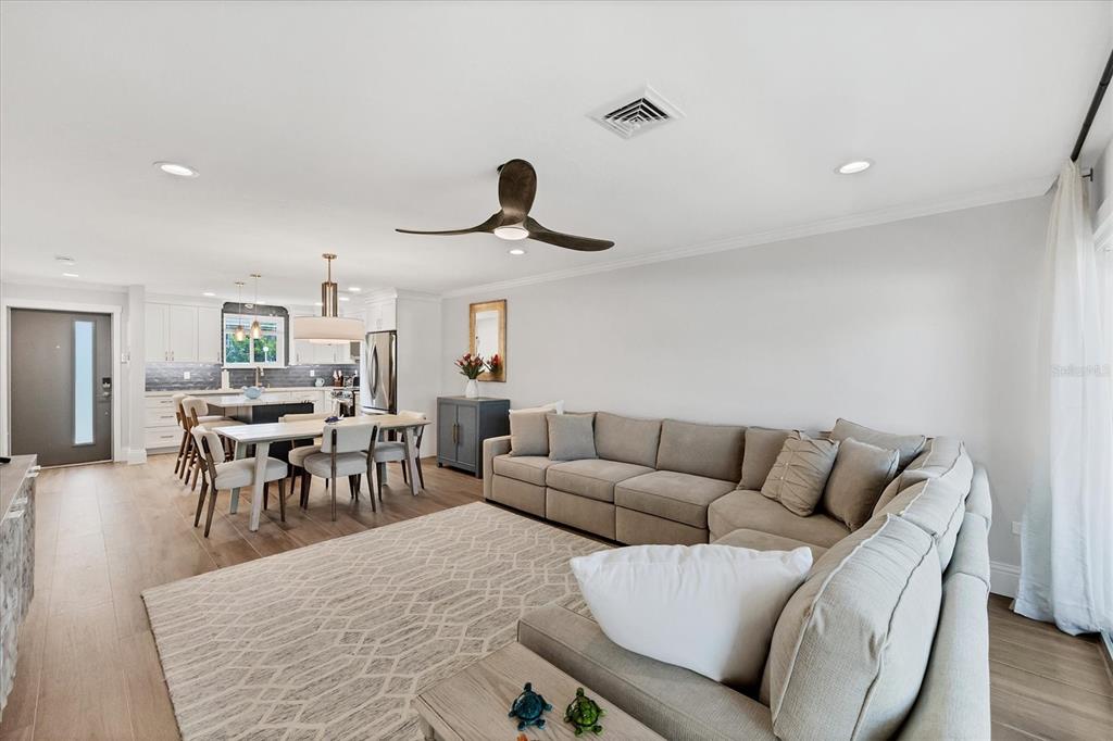 A living room with a large sectional sofa, area rug, and an open-concept kitchen — 500 S WASHINGTON DRIVE UNIT 11A, SARASOTA, FL