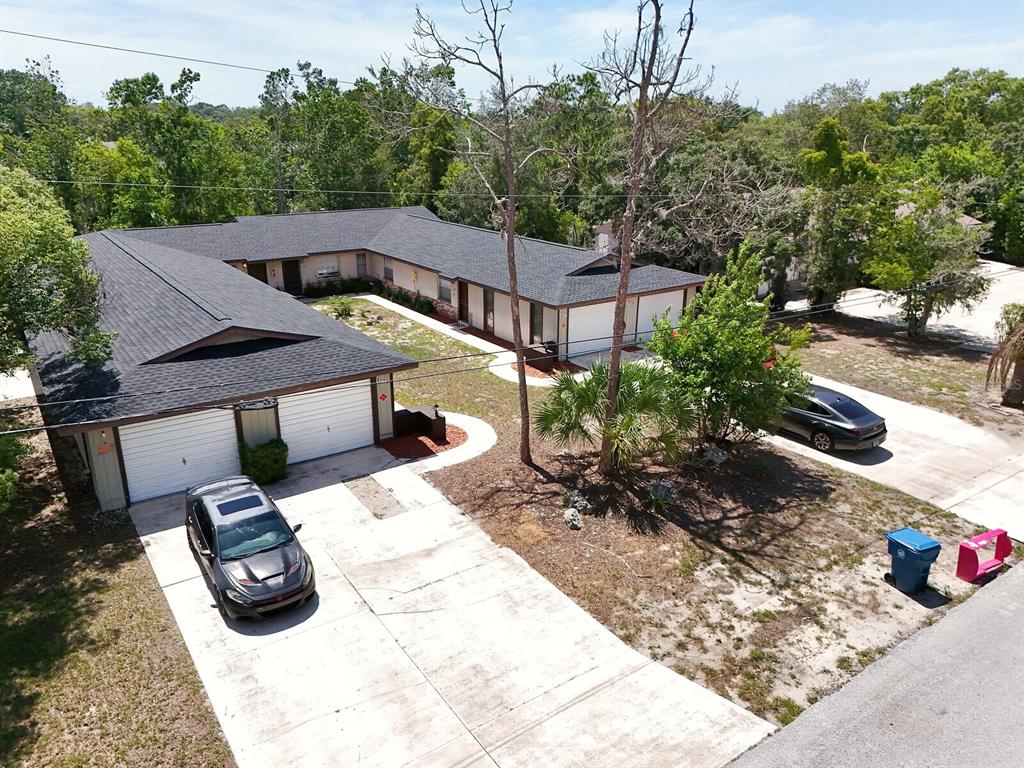 An aerial view of a single-story L-shaped residential building with two garages and driveways — 1277 SYLVIA AVENUE, SPRING HILL, FL