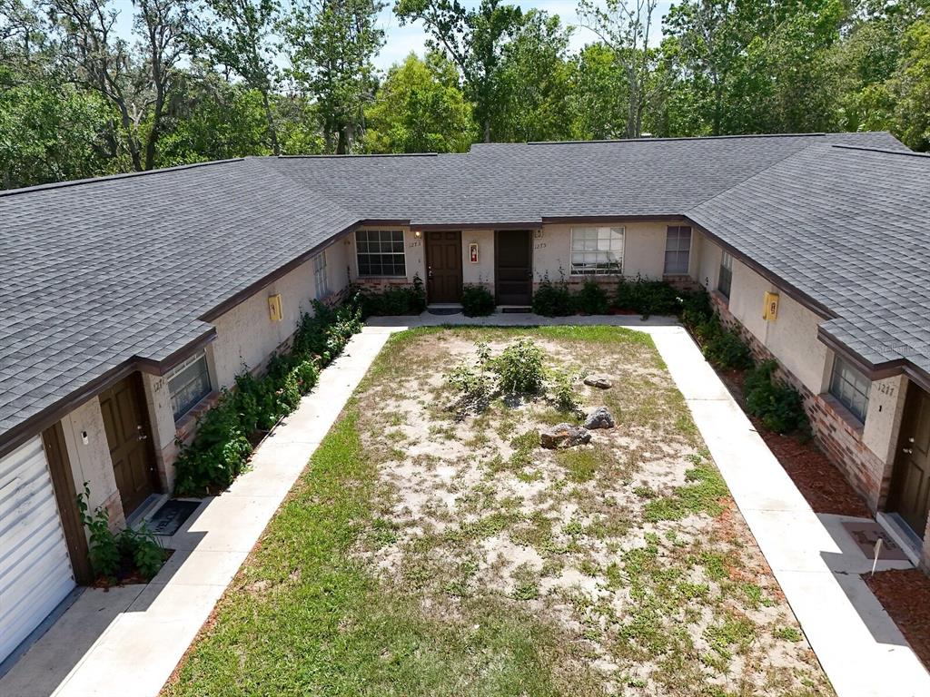 An aerial view shows the exterior of a U-shaped apartment building with a central courtyard — 1277 SYLVIA AVENUE, SPRING HILL, FL