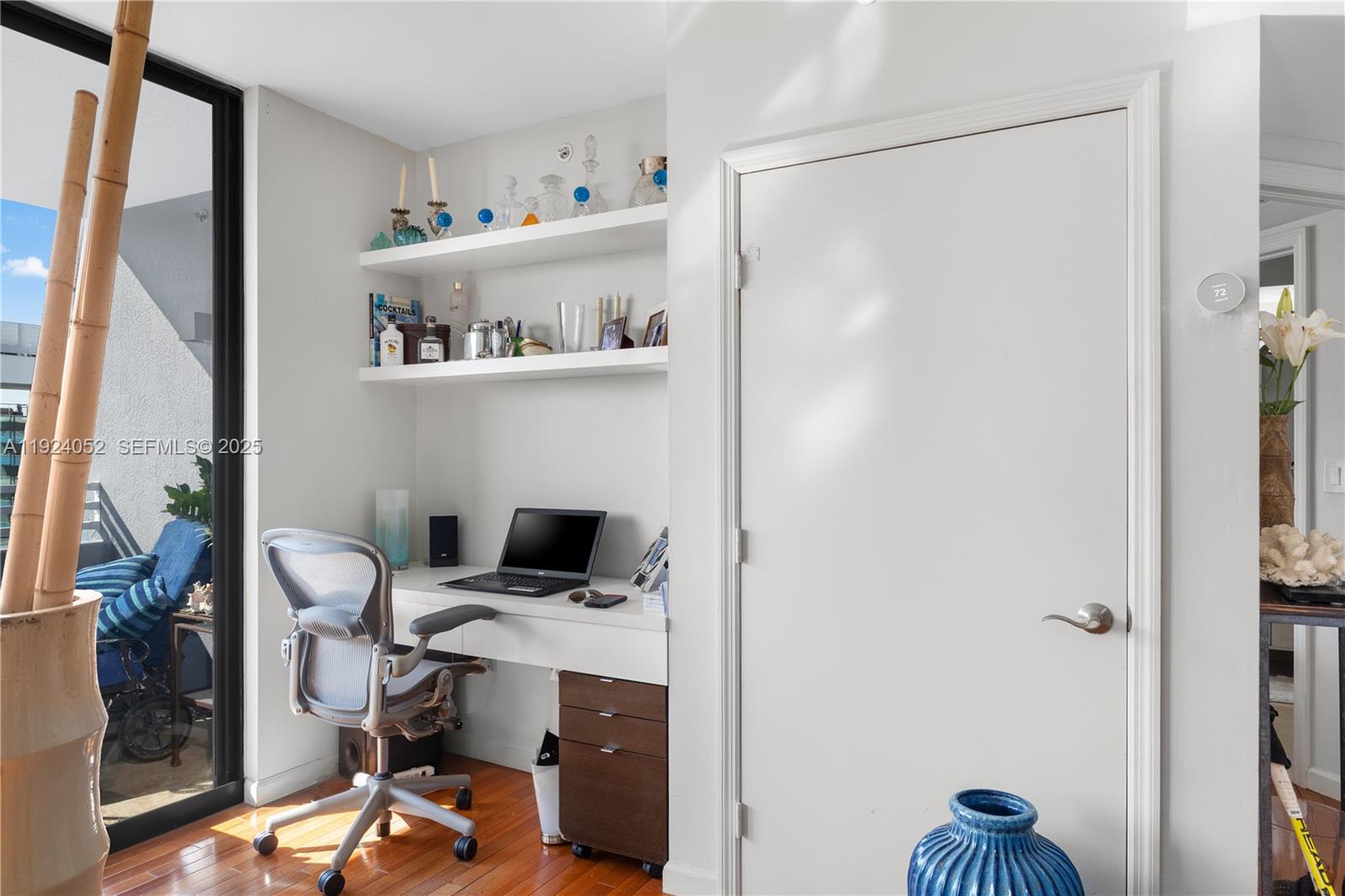 A home office nook features a desk, floating shelves, and a chair near a balcony — 1330 West Ave # 1712, Miami Beach FL 33139, MIAMI BEACH, FL