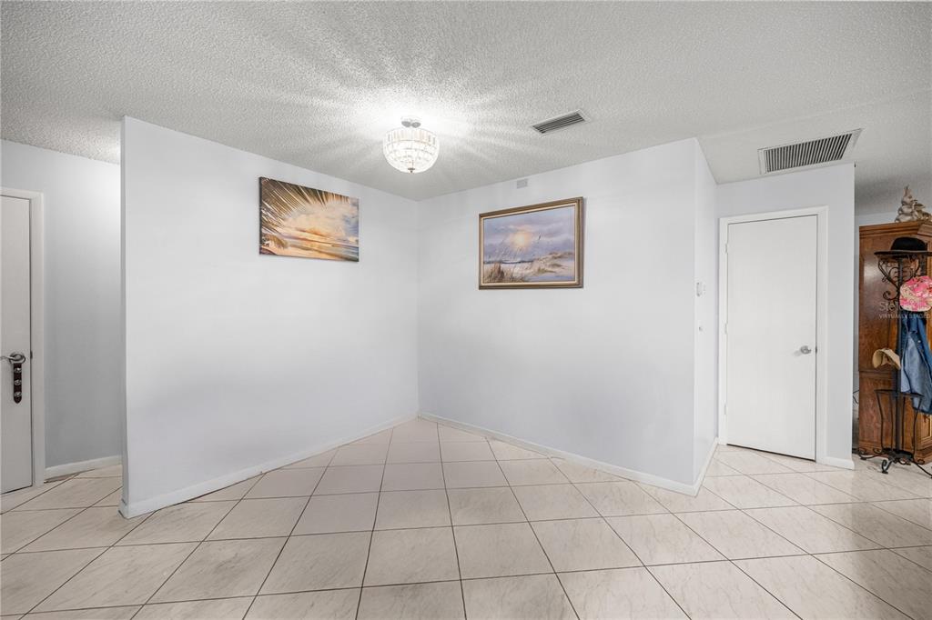 A covered front porch features tiled flooring, a ceiling fan, and outdoor seating — 9438 SW 85TH AVENUE UNIT B, OCALA, FL
