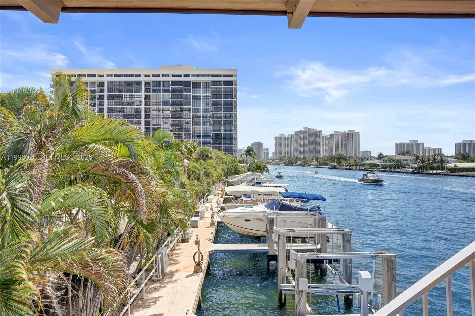 An elevated view shows a boat dock with several vessels along a canal near high-rise buildings — 1985 S Ocean Dr # 12A, Hallandale Beach FL 33009, HALLANDALE BEACH, FL