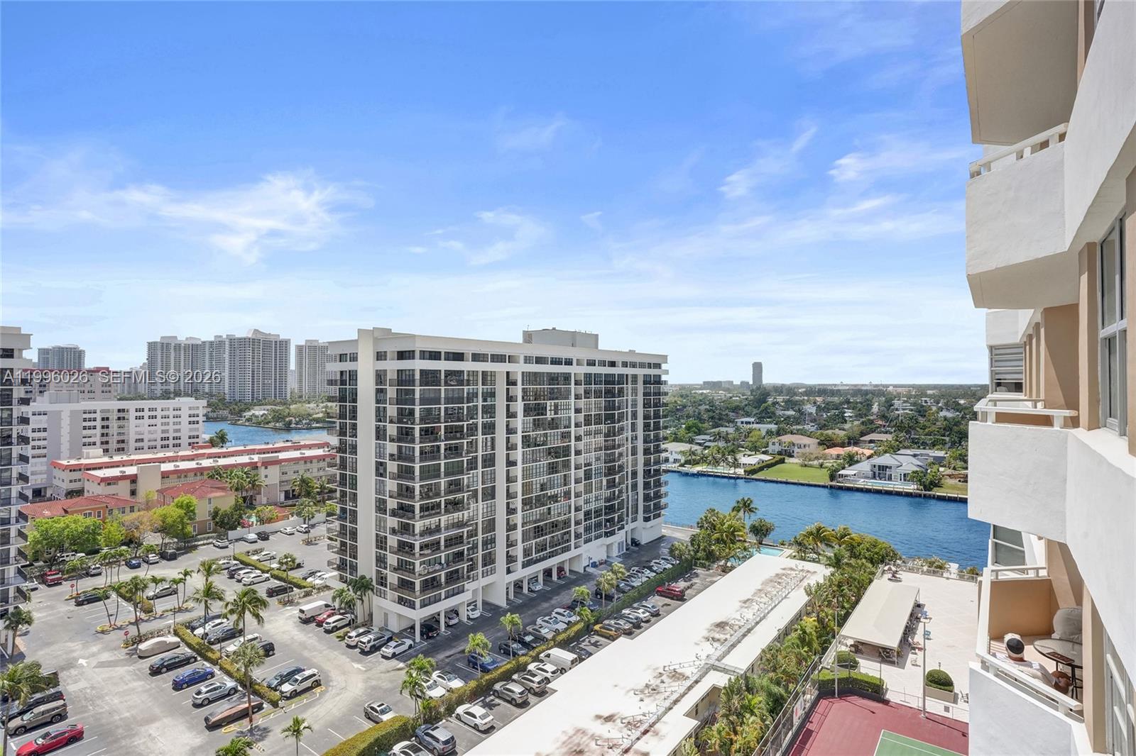 An elevated view shows a residential building, a parking lot, a canal, and distant city buildings — 1985 S Ocean Dr # 12A, Hallandale Beach FL 33009, HALLANDALE BEACH, FL