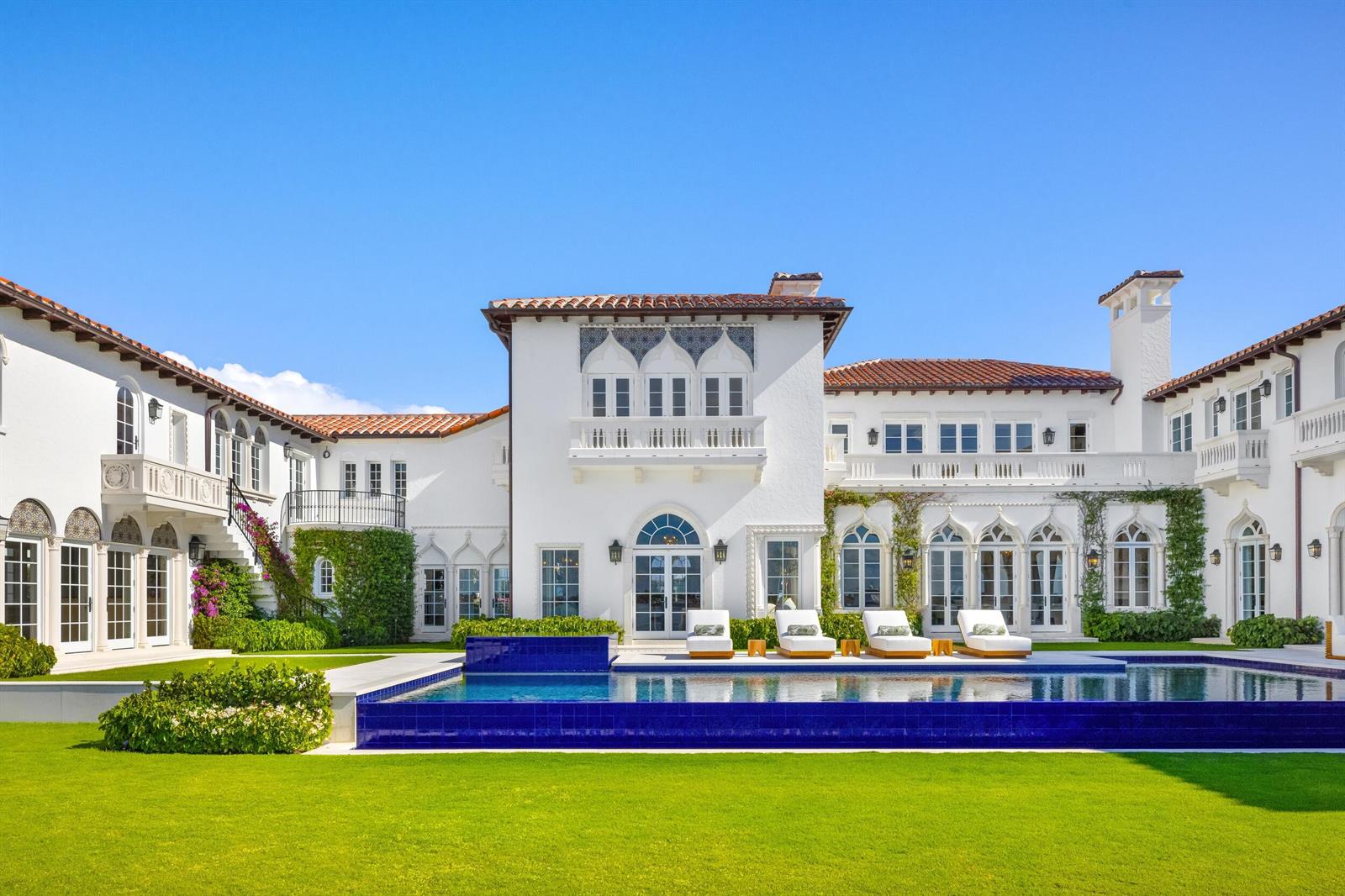 A white Mediterranean-style mansion with a blue-tiled pool and lawn under a clear blue sky — 800 S County Road, Palm Beach FL 33480, PALM BEACH, FL