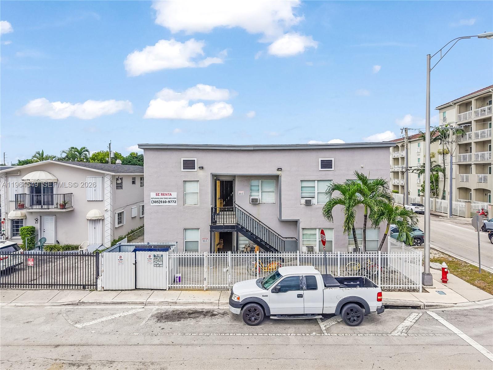 A two-story gray apartment building with a white fence and a white pickup truck parked outside — 508 W 1st Ave, Hialeah FL 33010, HIALEAH, FL