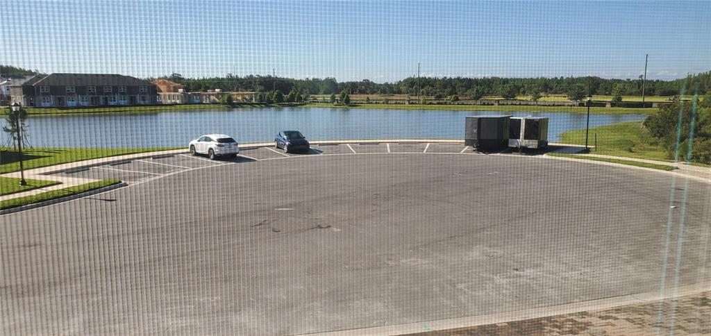 An elevated view shows a parking lot with two cars and two trailers by a lake — 29821 SOUTHWELL LANE, WESLEY CHAPEL, FL