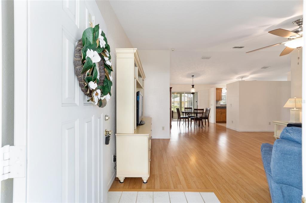 An entryway leads into a living area with wood flooring, a dining set, and kitchen — 10169 SW 63RD AVENUE, OCALA, FL