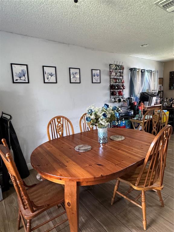 A dining room features a wooden oval table, four chairs, and wall-mounted floral artwork — 513 OAKCREST STREET, ALTAMONTE SPRINGS, FL