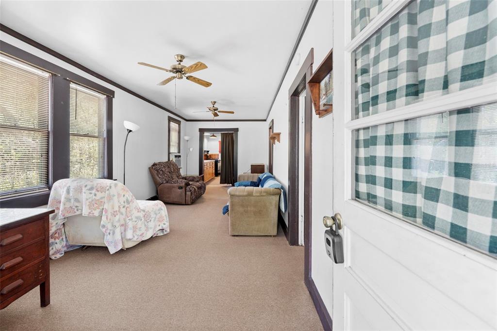 A living room with beige carpet, white walls, dark trim, and two ceiling fans — 11317 SALINA STREET, BROOKSVILLE, FL