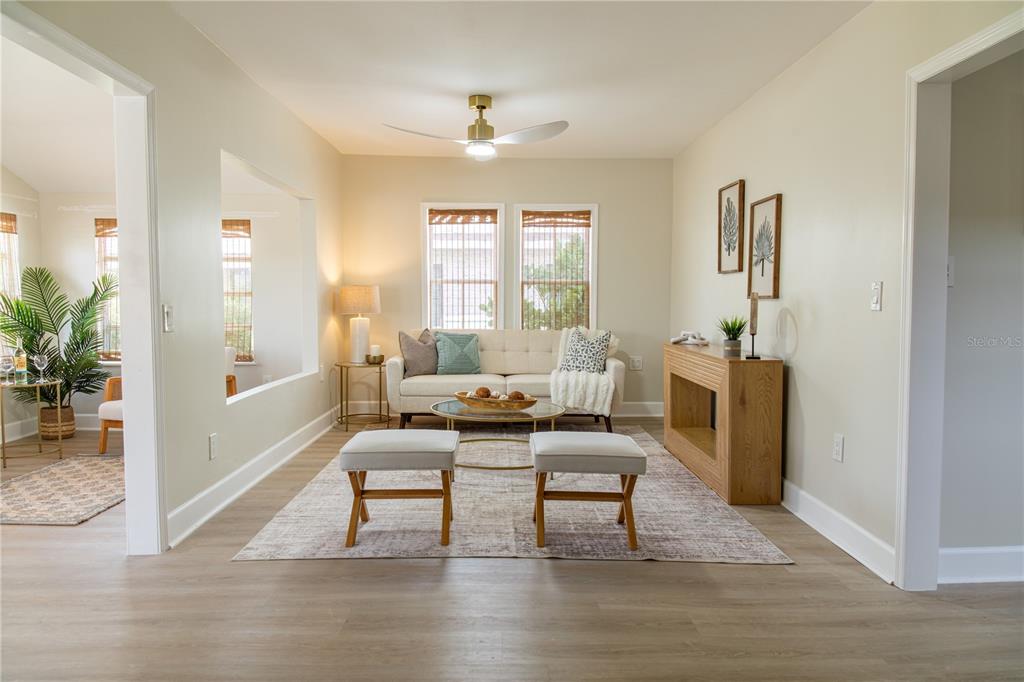 A living room features a sofa, two ottomans, a coffee table, and a wooden console — 13148 3RD STREET E, ST PETERSBURG, FL