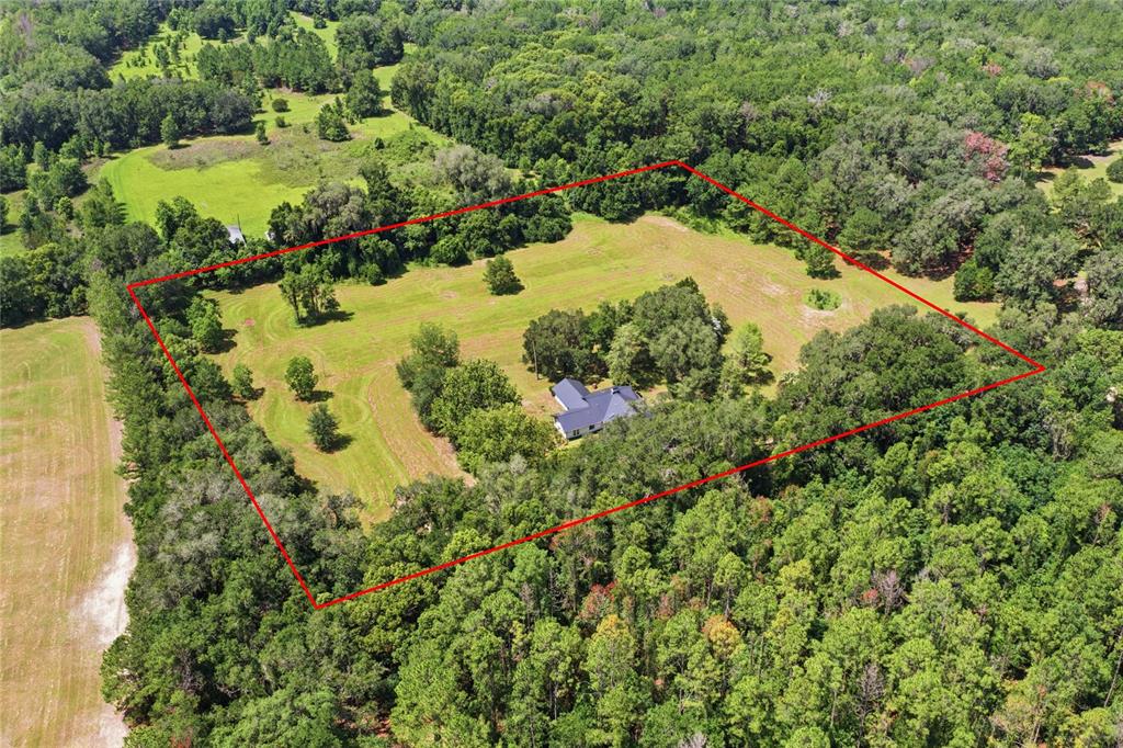 An aerial view shows a house situated in the center of a large, grassy lot — 22929 E COUNTY ROAD 1474, HAWTHORNE, FL