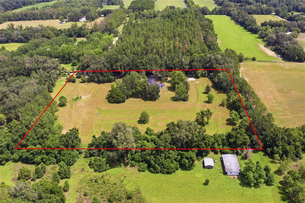 An aerial view shows a house situated on a large, rectangular, tree-lined grassy lot — 22929 E COUNTY ROAD 1474, HAWTHORNE, FL