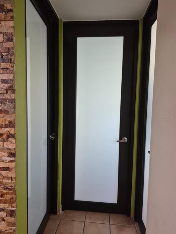 A hallway features a dark-framed door with a frosted glass panel and tiled flooring — I-205 VILLAS DEL MAR RESORT UNIT I-205, LOIZA, PR