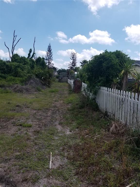 A dirt path runs between a white picket fence and a dense area of vegetation — 21 MILWAUKEE AVENUE, PALM COAST, FL