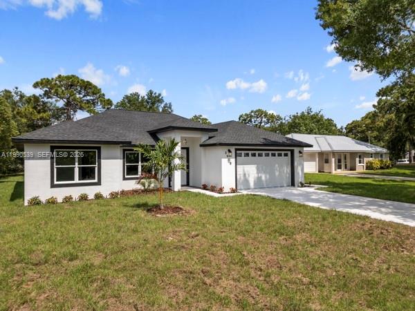 A white single-story house with a dark roof and a two-car garage sits on grass — 3908 Garienda Ave, Sebring FL 33872, SEBRING, FL