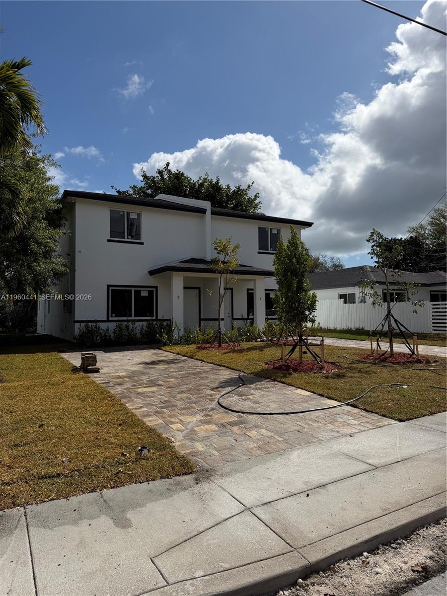 A two-story duplex with a paved driveway and newly planted trees in the front yard — 7823 NW 5th Ave, Miami FL 33150, MIAMI, FL