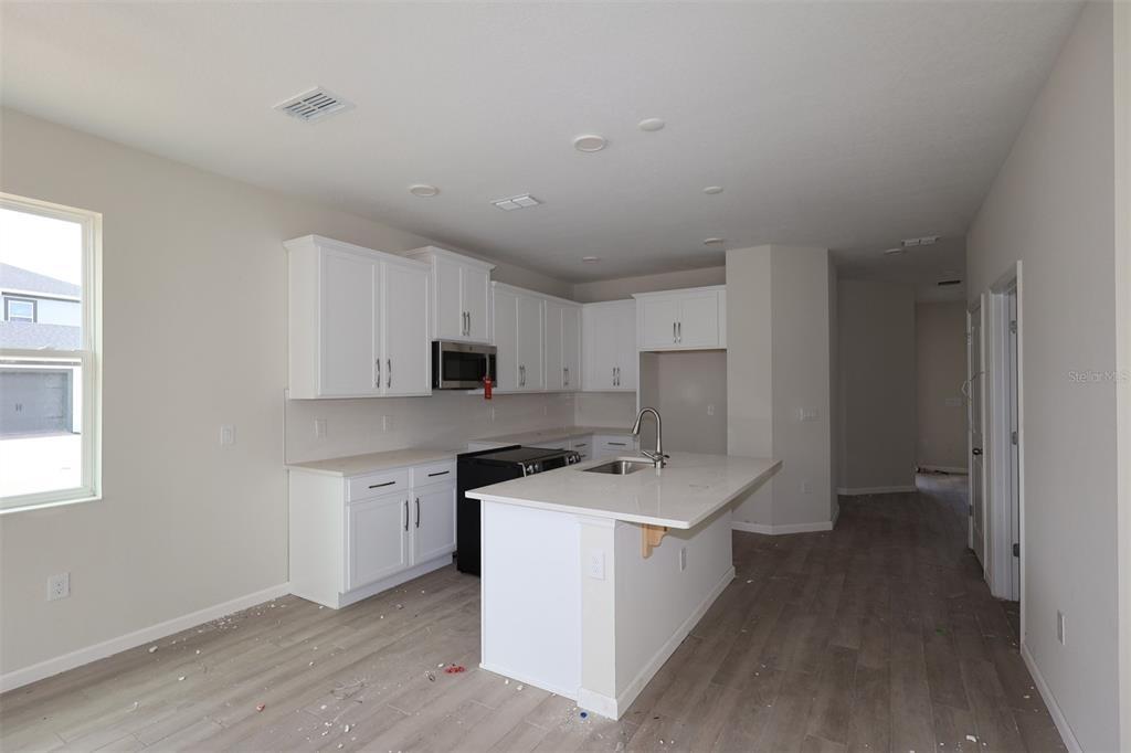 An empty room features beige walls, white trim, and a partially open closet door — 1429 HYDE STREET, ST CLOUD, FL