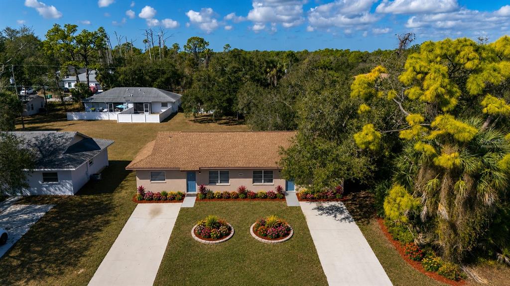 An aerial view shows a single-story duplex with two driveways and landscaped front flower beds — 2087 COMO STREET UNIT B, PORT CHARLOTTE, FL