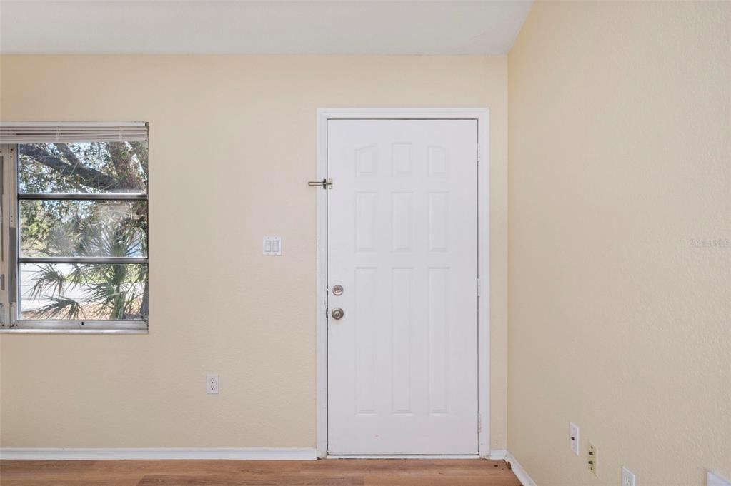 An interior room view features a white door, a window, and light-colored walls — 2087 COMO STREET UNIT B, PORT CHARLOTTE, FL